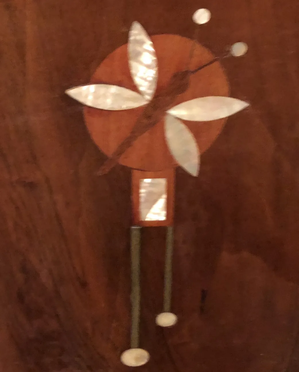 Cama antiga com decorações de incrustações na cabeceira.