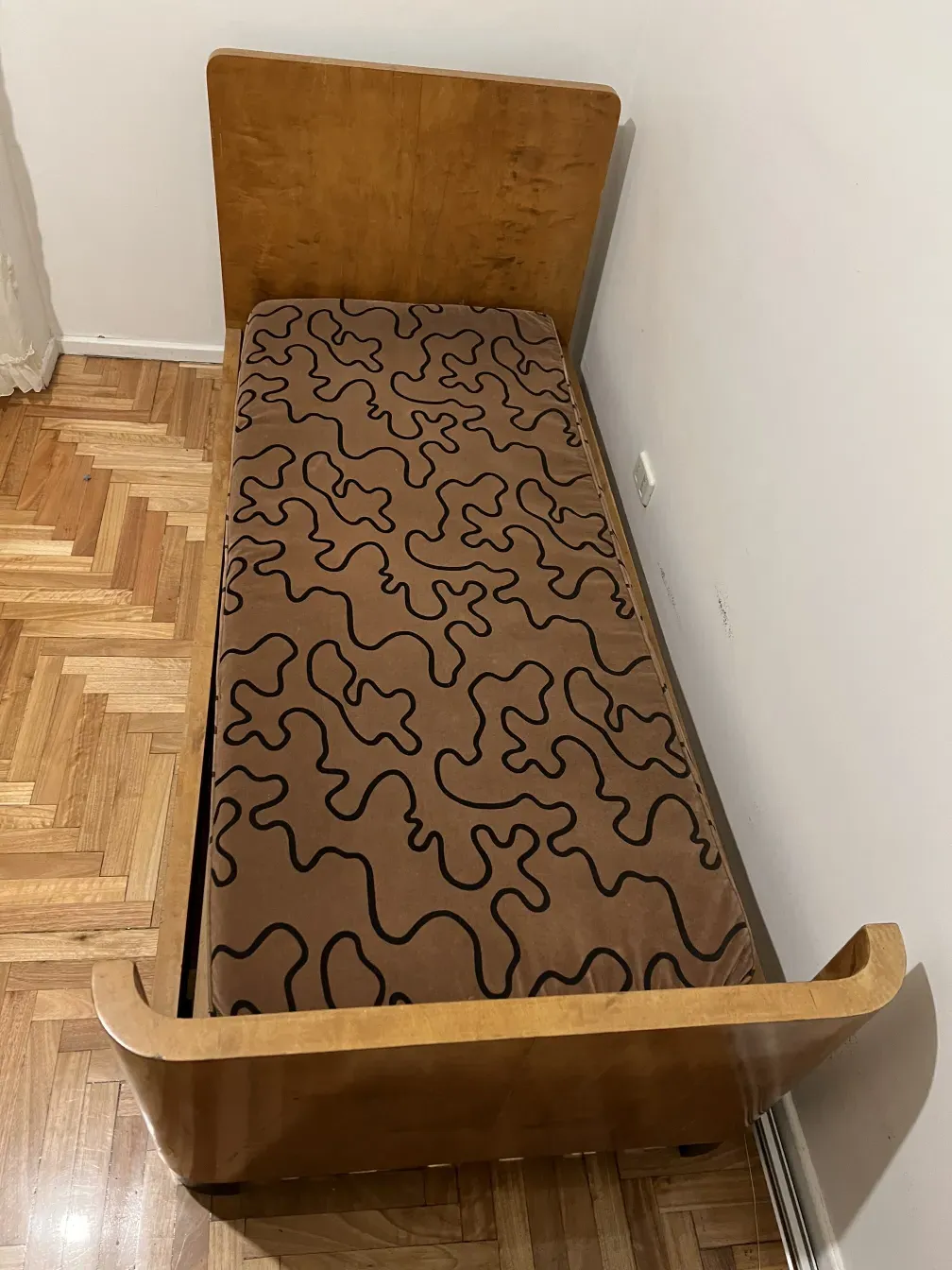 Lit ancien avec matelas à motifs et bois clair