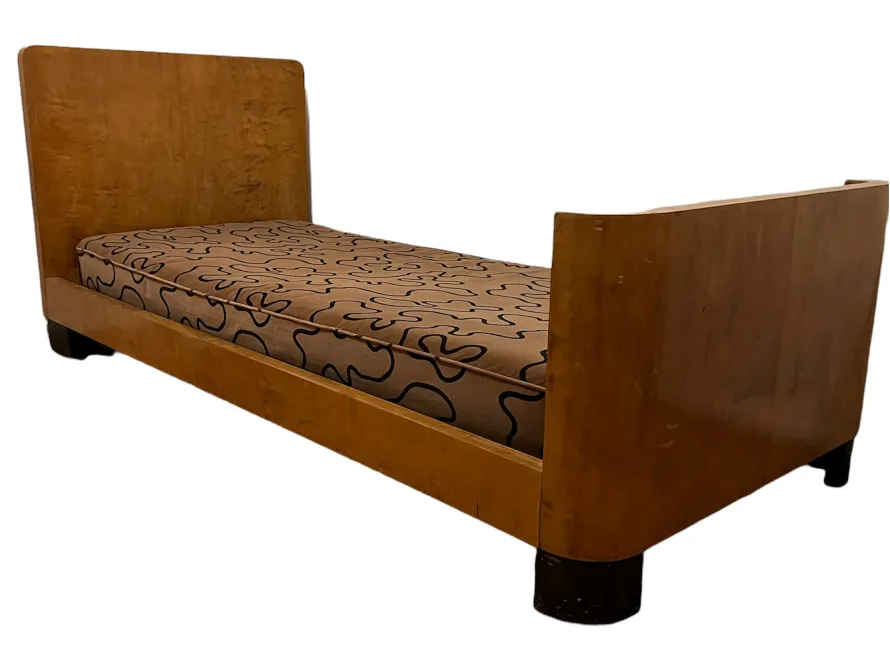 Antique wooden bed with decorative mattress and rounded feet