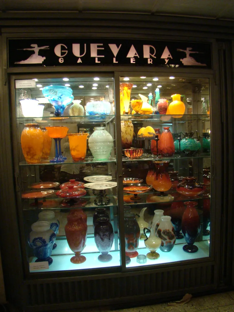 Antique signed glass Muller Fres displayed with colorful items.