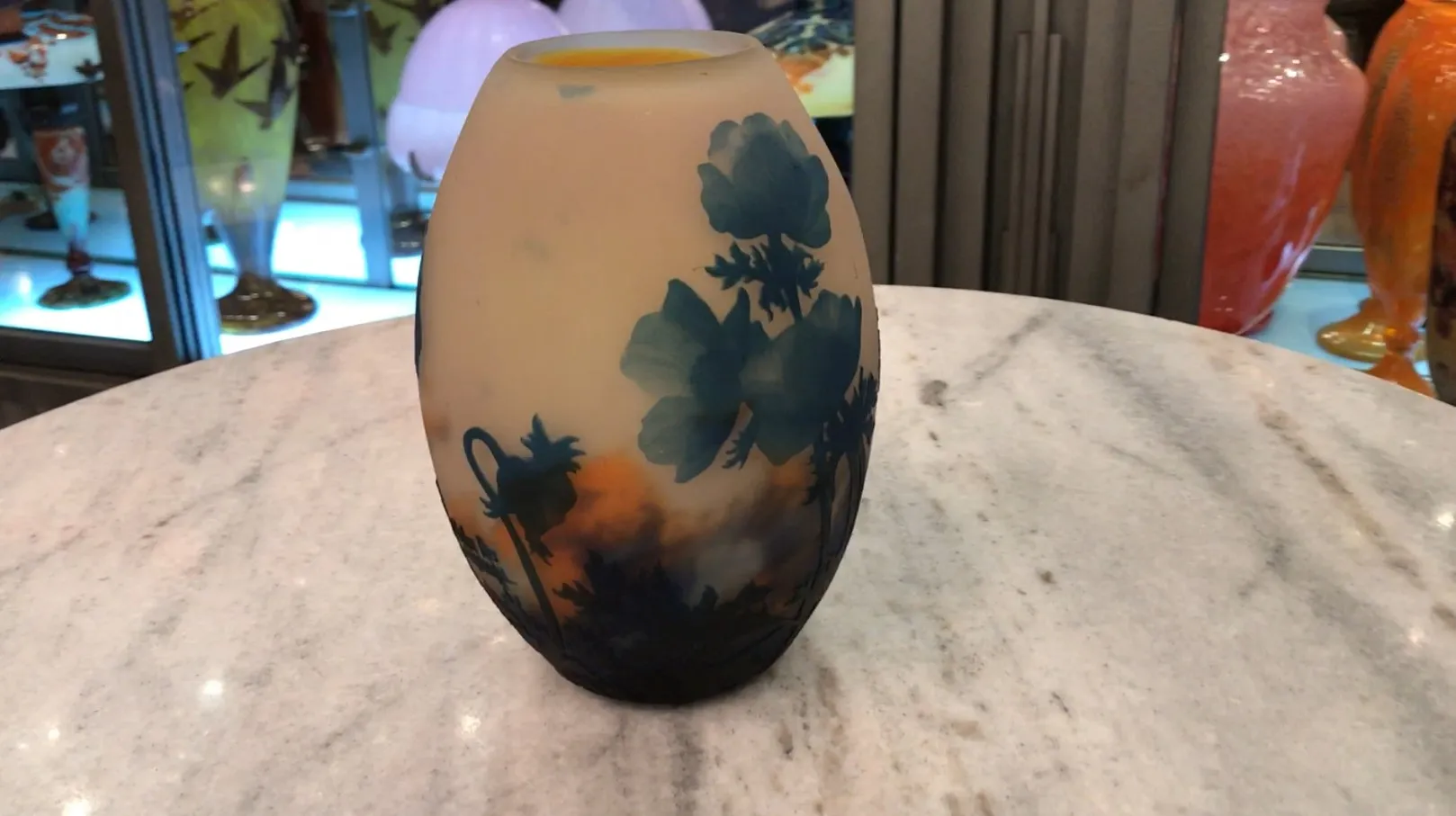 Vaso de cristal antiguo con flor azul y ambiente elegante