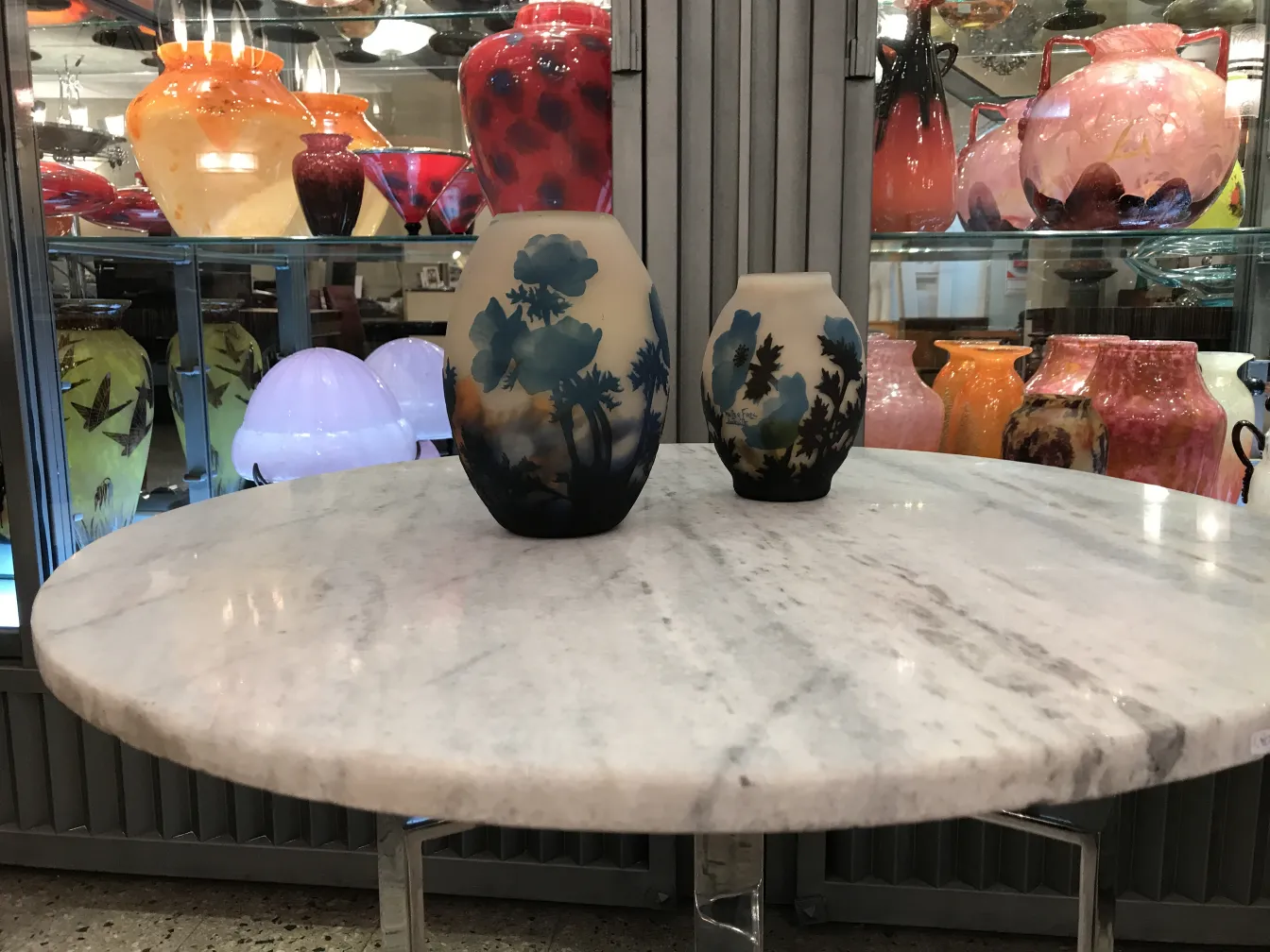 dois vasos com design floral, um grande e um pequeno, fundo colorido