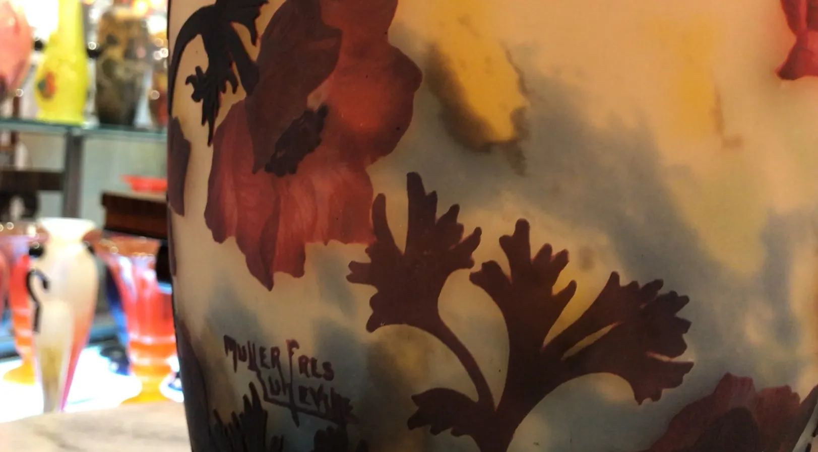 Verre signé Muller Fres avec un motif floral en tons jaunes et rouges, ambiance d'antiquités.