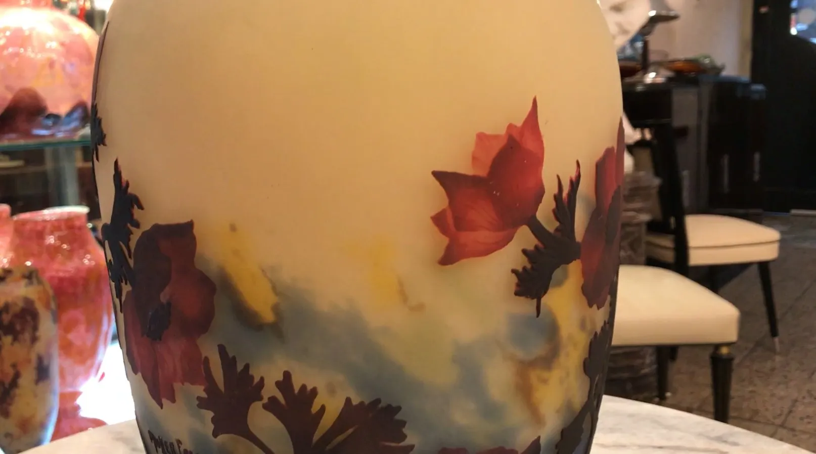 Ancienne bouteille en verre signée par Muller Fres avec des couleurs et des fleurs.