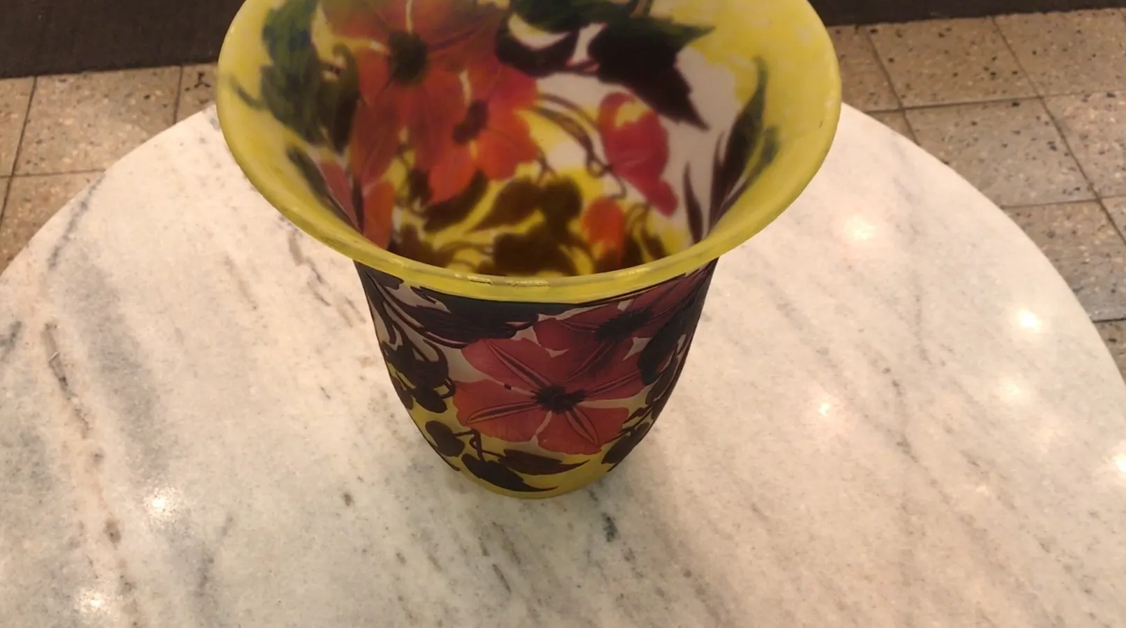 Vaso antiguo firmado por Muller Fres con diseño floral colorido, en un entorno elegante.