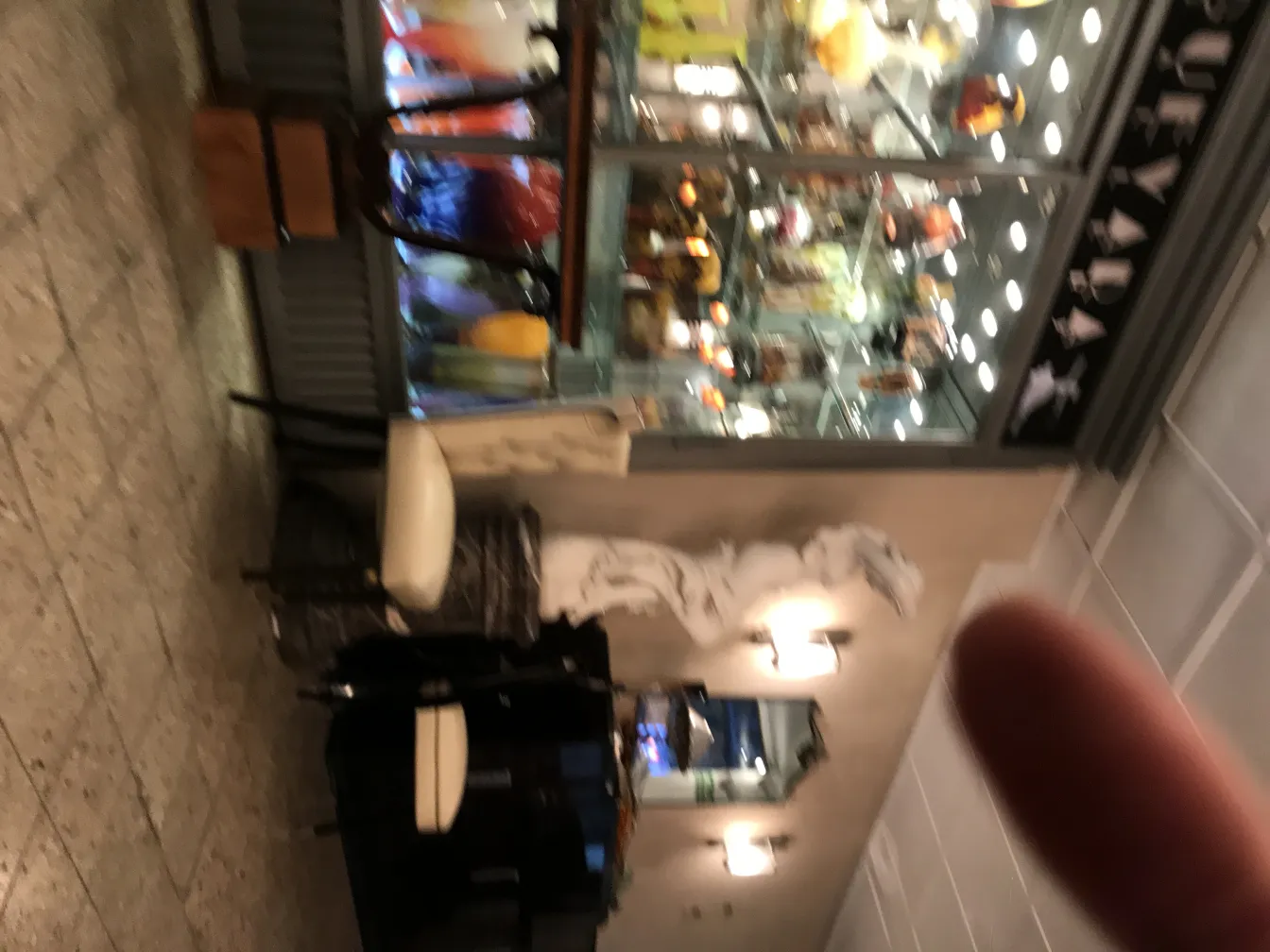 Vidrio firmado Muller Fres, antigüedad, exhibido en la tienda con otros objetos decorativos coloridos.