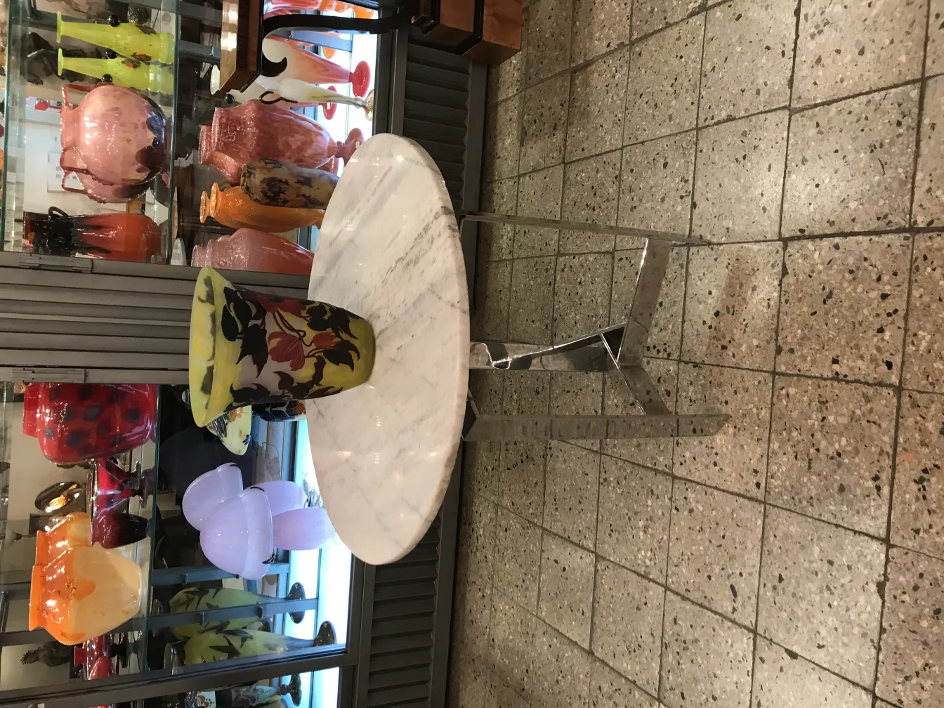 Antique signed glass vase by Muller Fres on display, various colors.