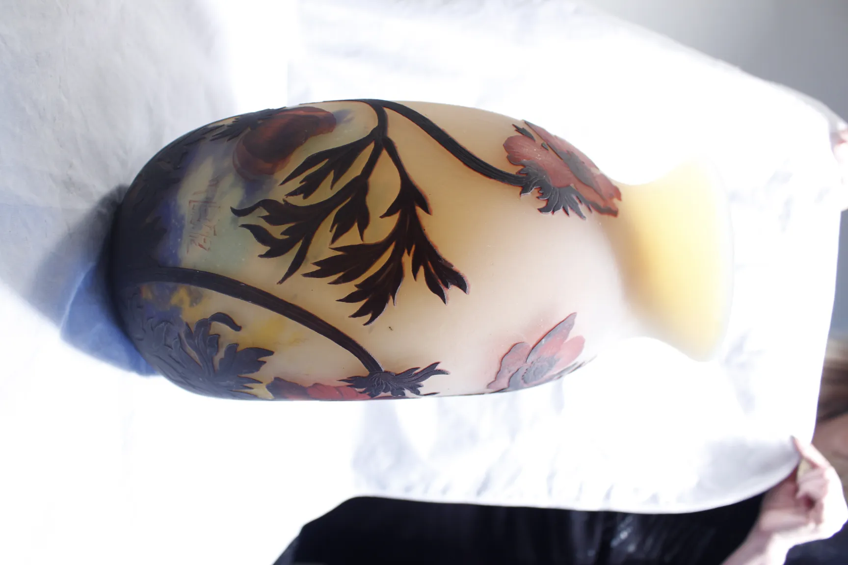 Verre signé Muller Freres avec design floral ancien, fond doux.