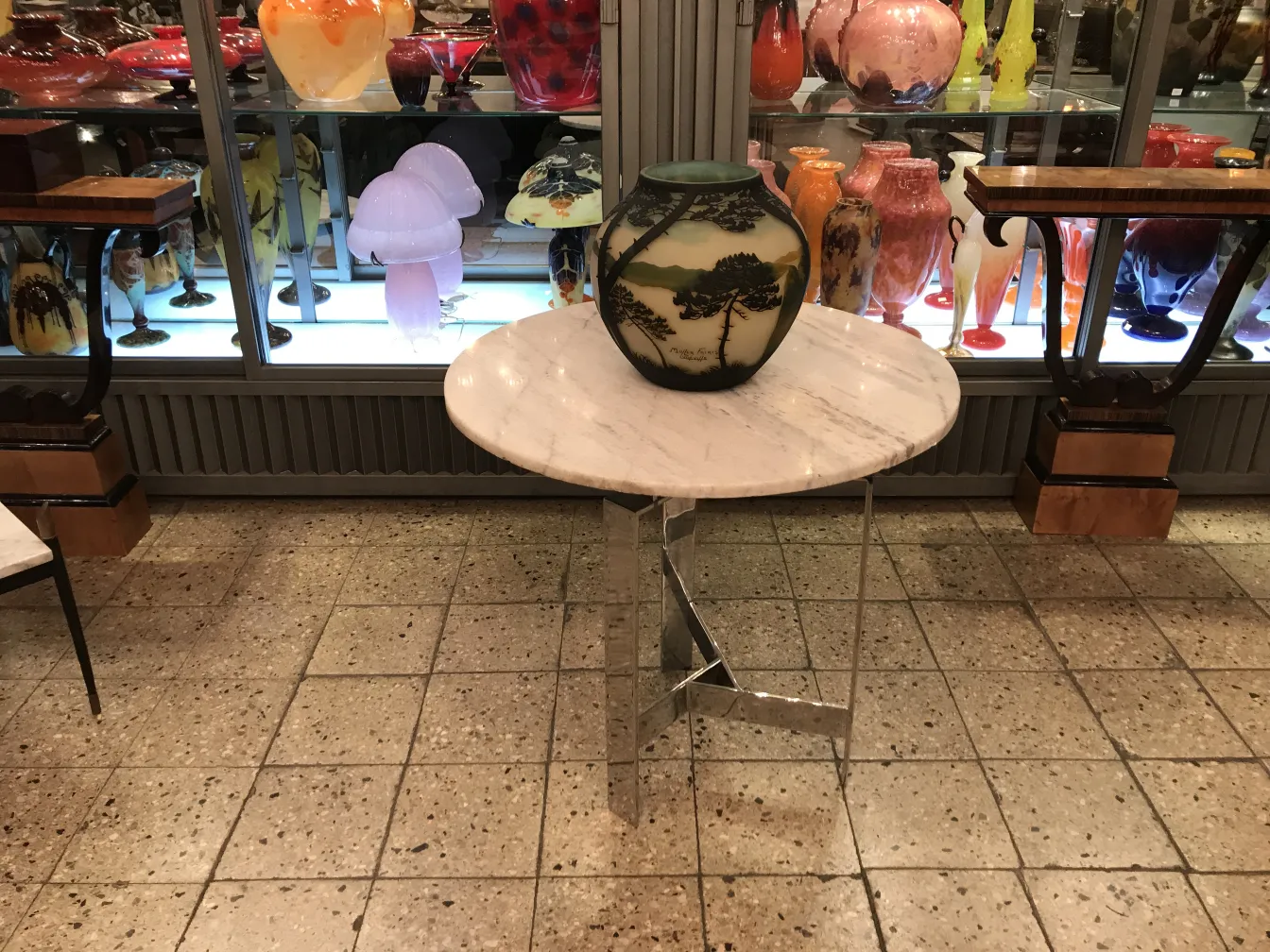 Vetro firmato di Muller Fres esposto su un tavolo con altre antichità.