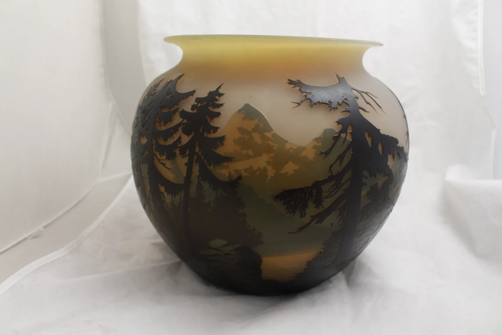 Antique vase with landscape and trees design on the surface.