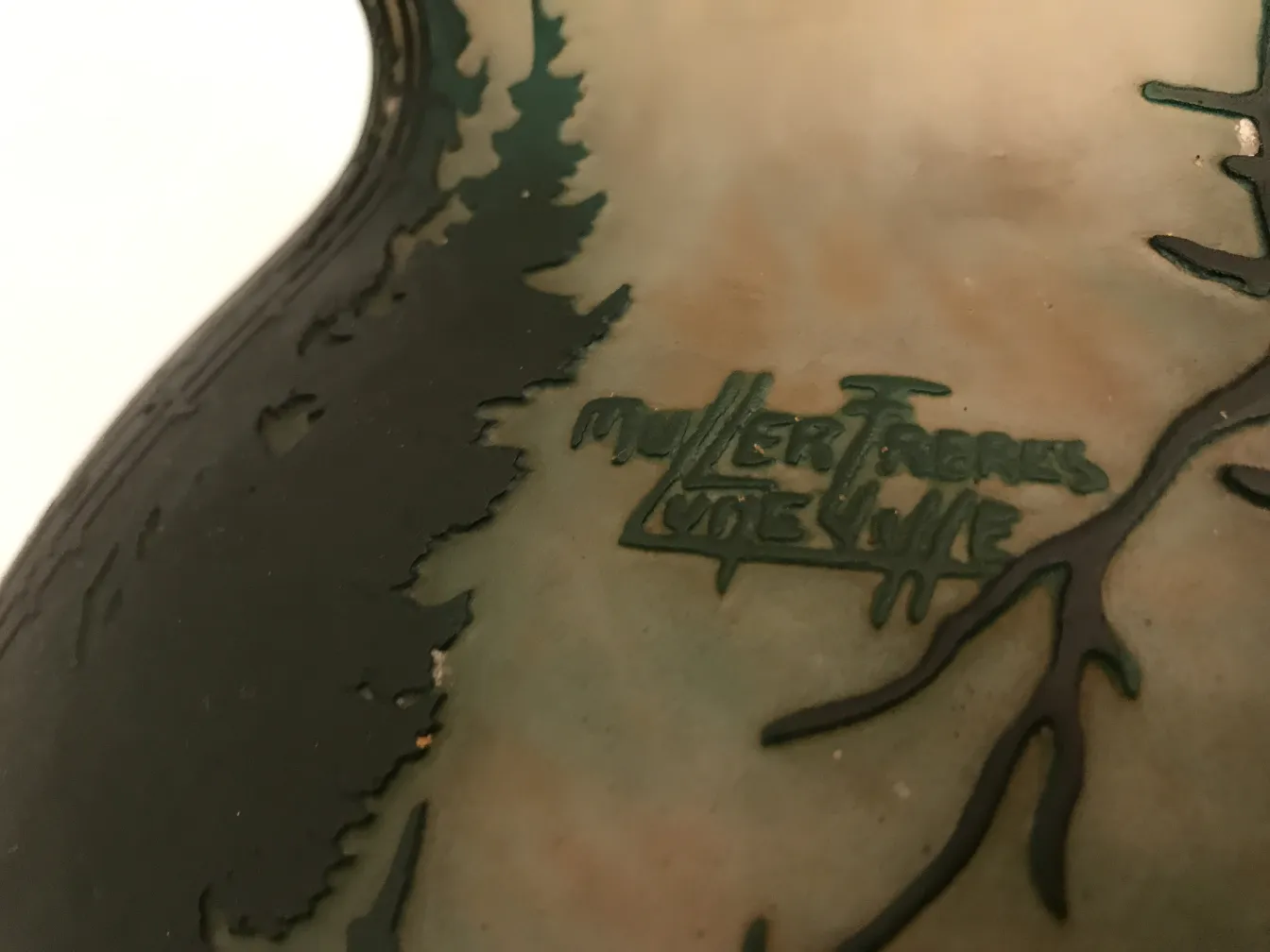 Close-up of an antique signed glass Muller Freres with nature design