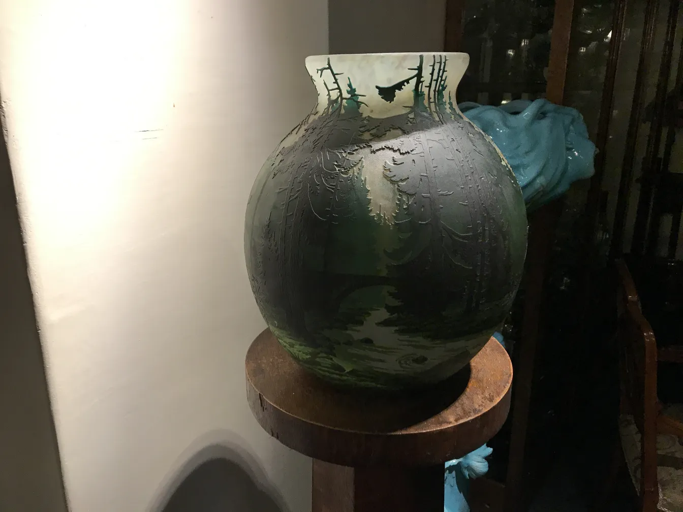 签名玻璃由Muller Fres装饰，色调较暗，展示在木制货架上。