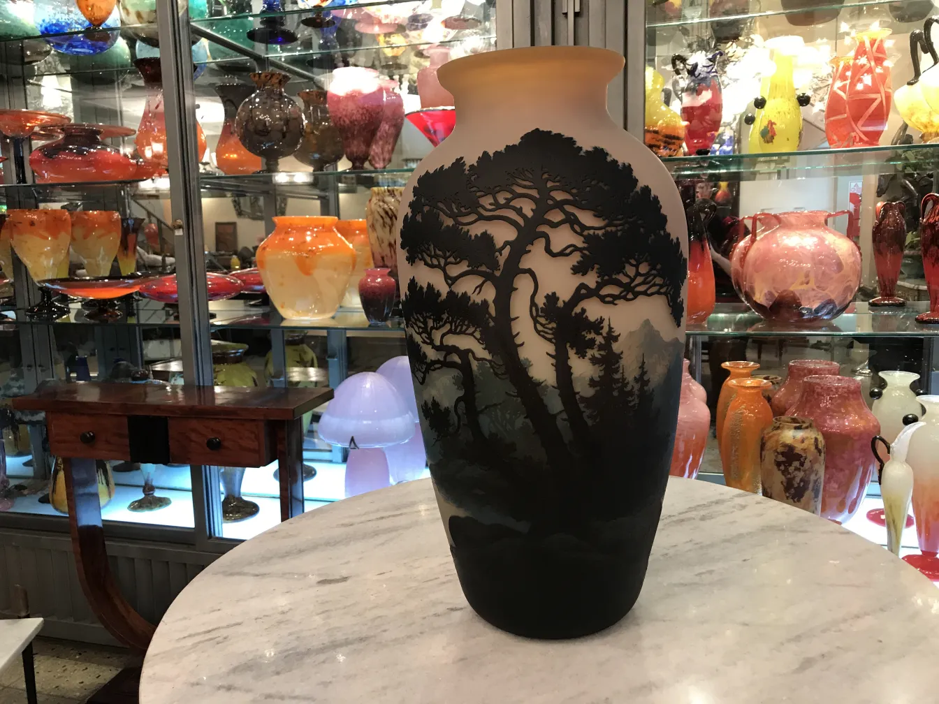 Signiertes Glas Muller Fres mit antikem Design und Landschaft, umgeben von verschiedenen dekorativen Gegenständen.