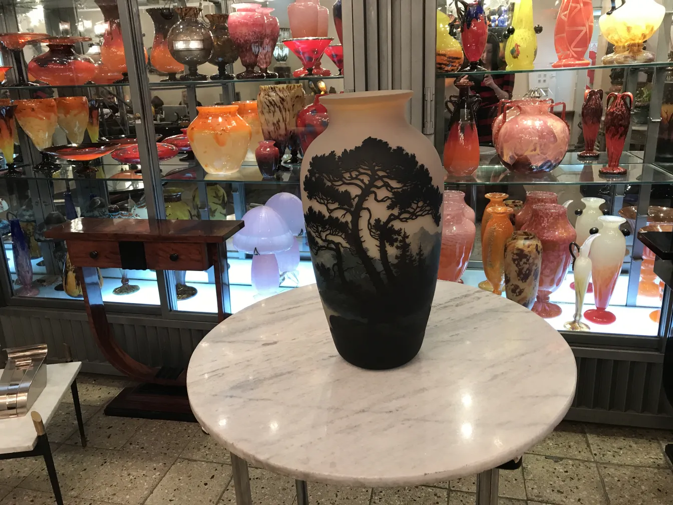 Antike Vase mit Baumdesign von Muller Freres in dekorativer Umgebung.