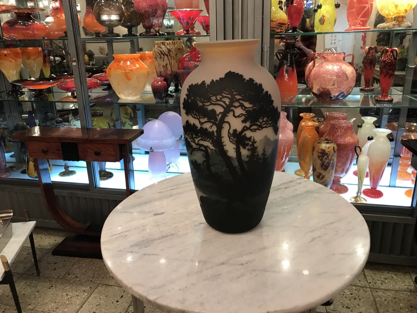 Beau vase ancien signé Muller Fres parmi des objets en verre colorés.