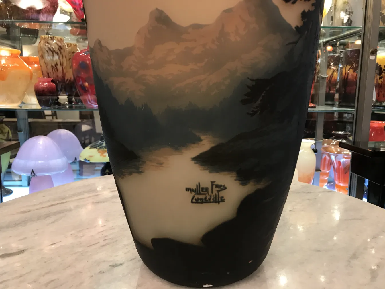 Verre signé ancien Muller Frères avec reliefs de paysages et fond décoratif.