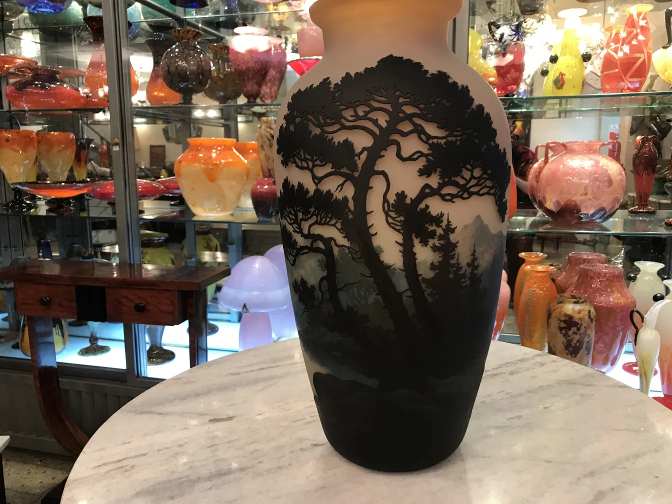 Vaso di vetro antico firmato da Muller Fres con un design paesaggistico, includente alberi e montagne su uno sfondo colorato.