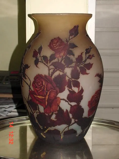 Vaso antigo com rosas vermelhas e verdes em design floral, assinado