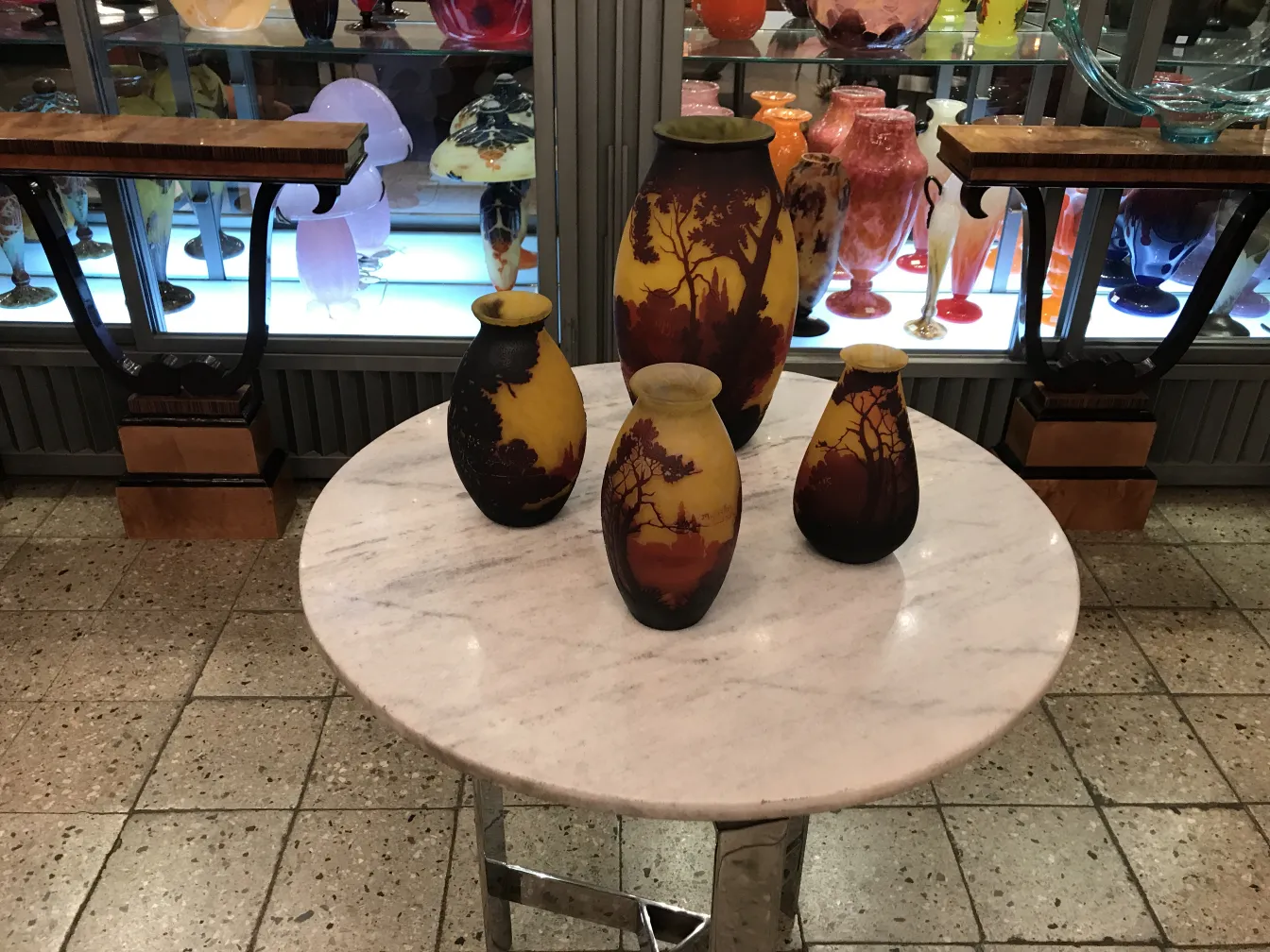 jarrones antiguos en una mesa con decoraciones coloridas de muller freres