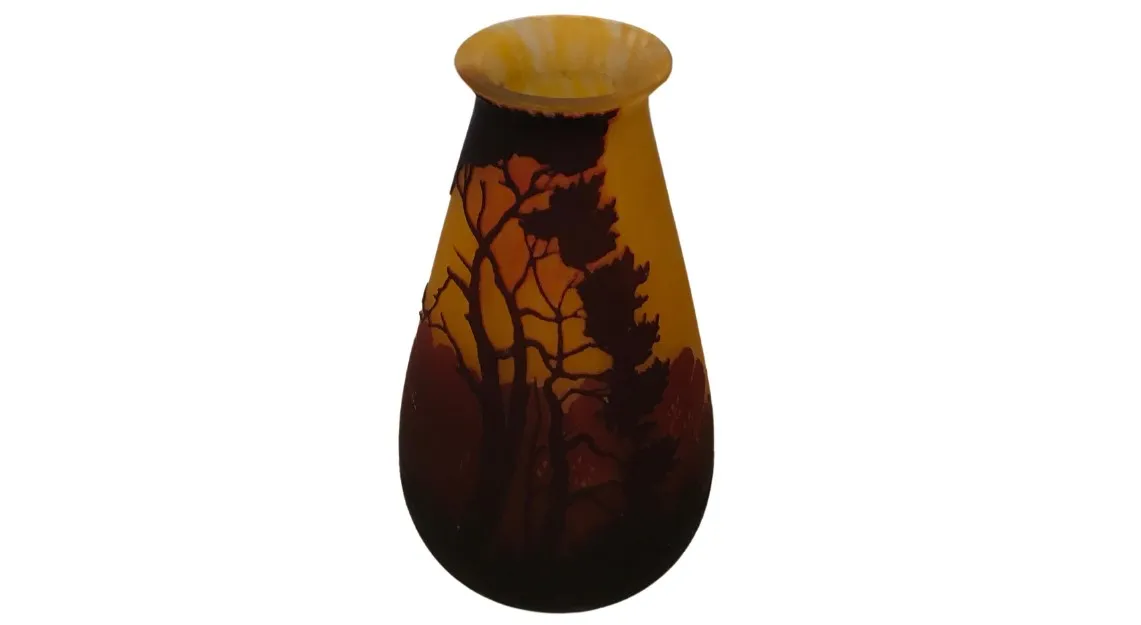 Antigo vaso com detalhes em tons de laranja e marrom, árvores em silhueta