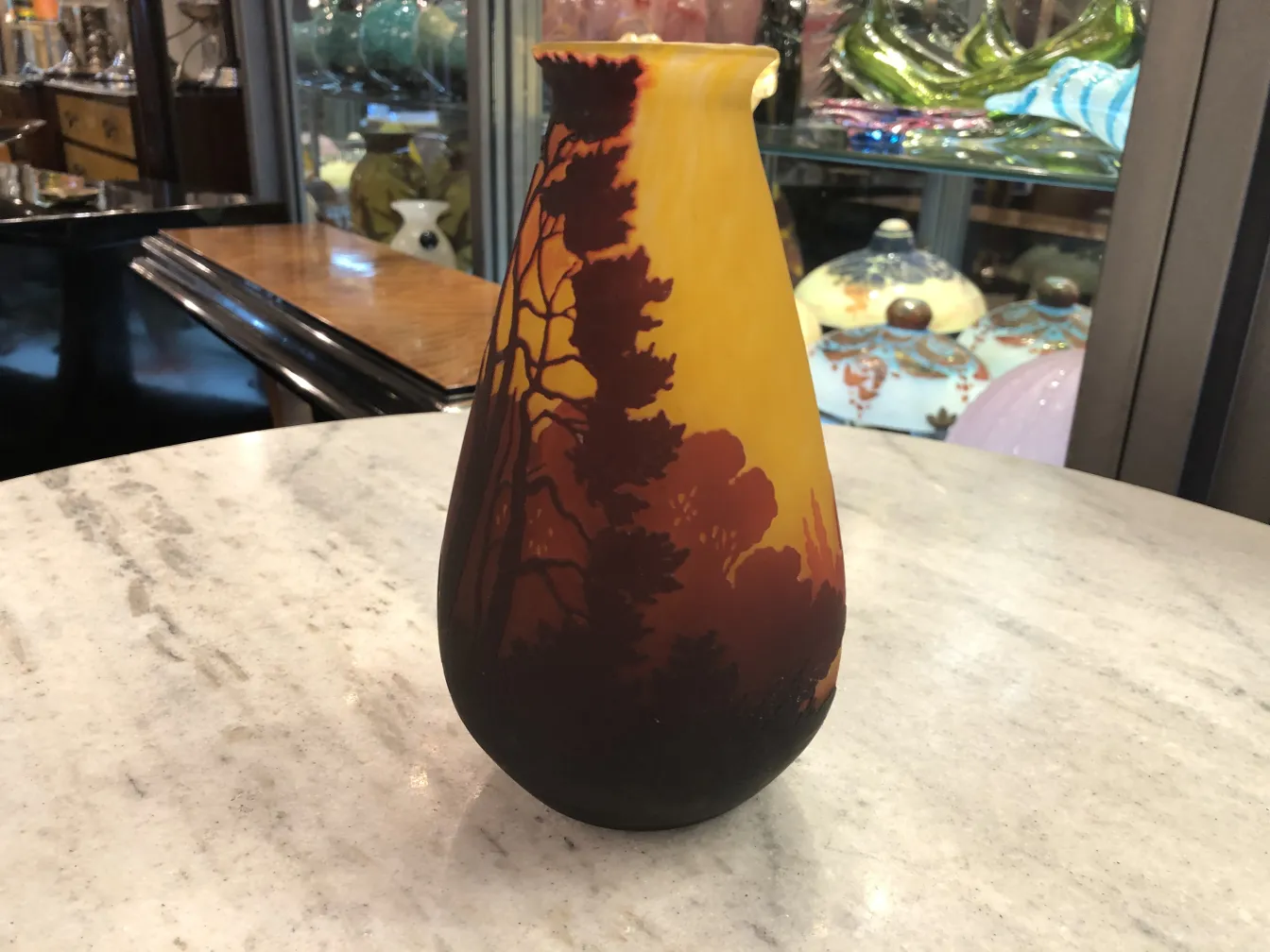 vase of signed glass with muller fres landscapes, antiques in background