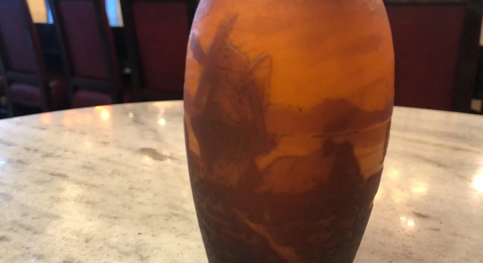 Vista de um vaso antigo, figura gravada, muller fres em uma mesa de mármore.