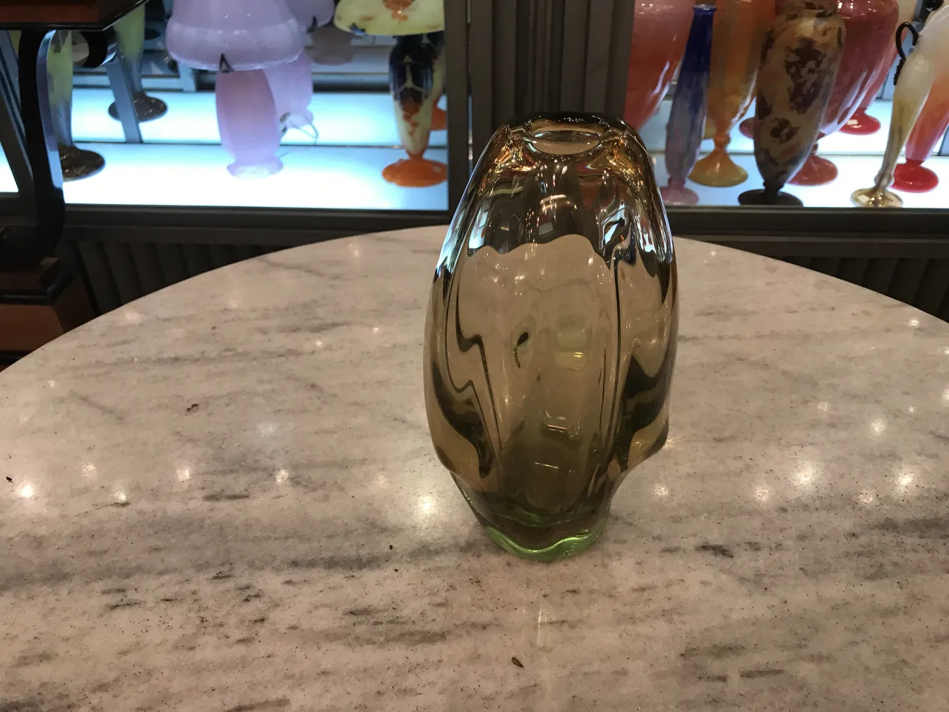 vaso di murano ovale su tavolo, sfondo di vari vasi