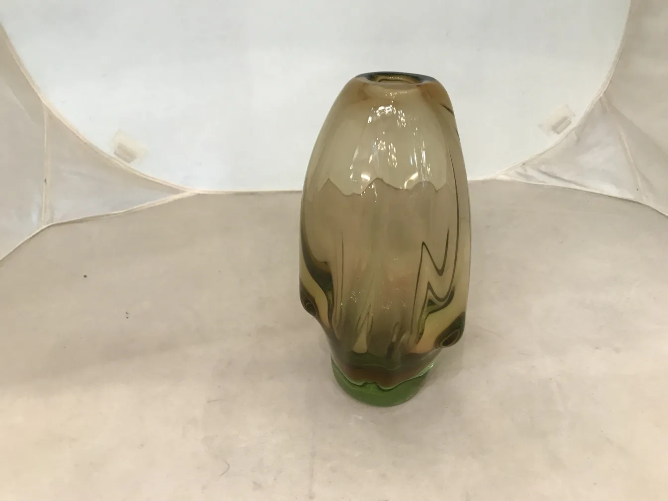 明るい背景の茶色と緑色の古代ムラーノ花瓶