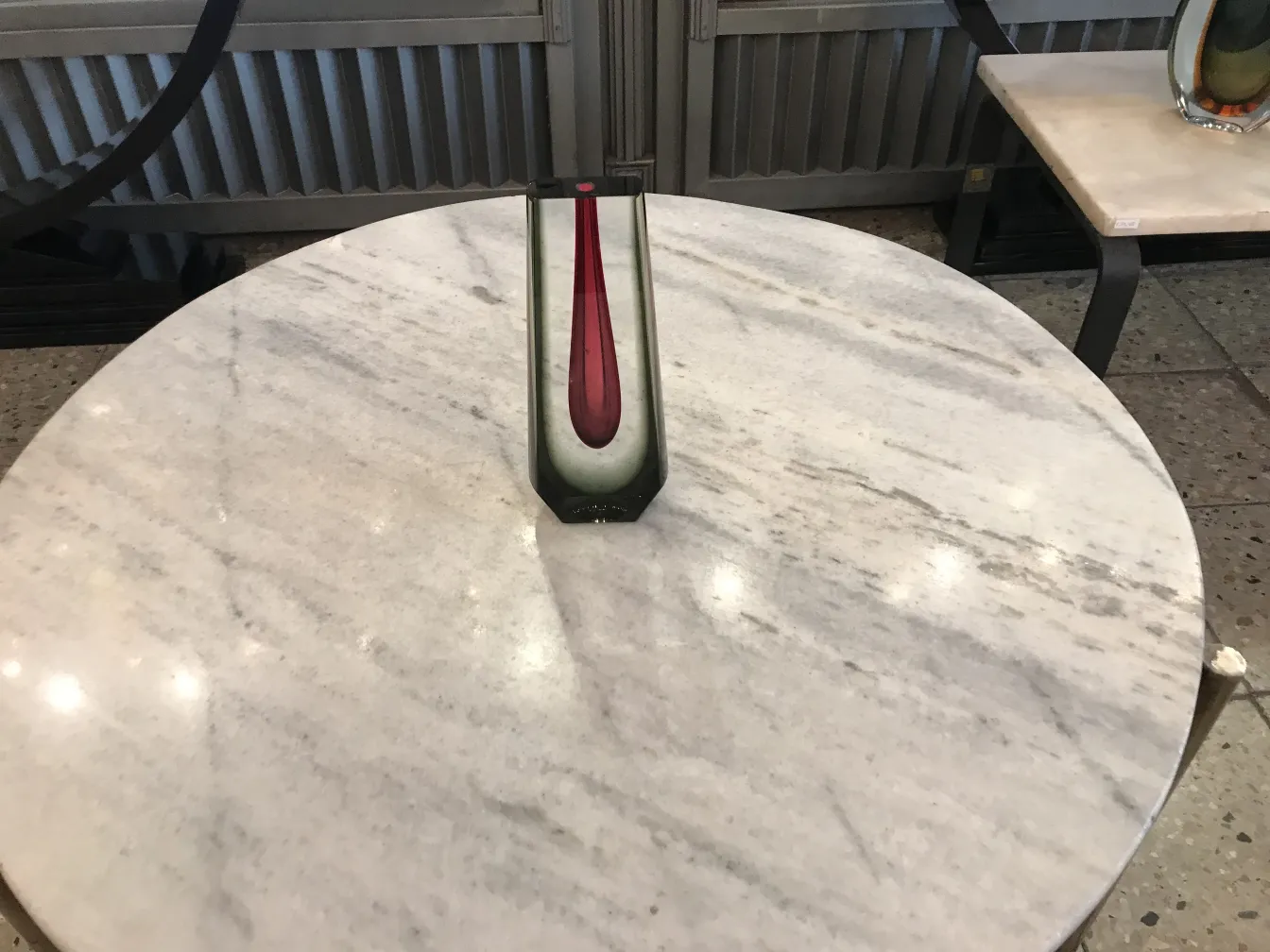vase murano sur une table en marbre avec fond varié