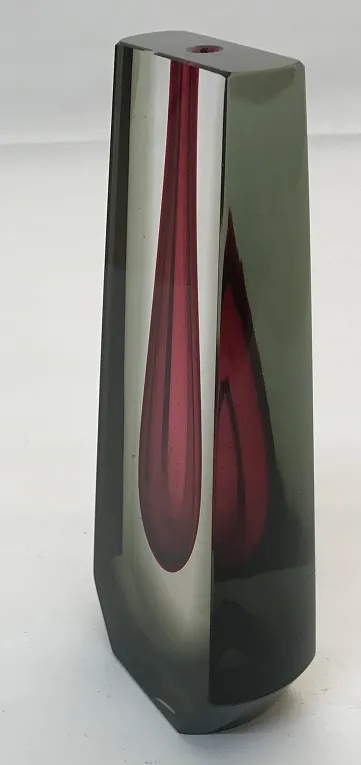 Vaso de Murano antigo com formas geométricas, cores escuras, em um ambiente elegante