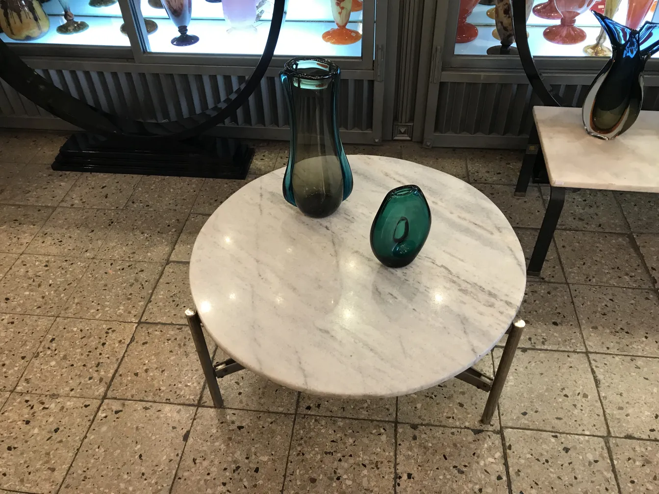 florero de murano antiguo sobre mesa de mármol con otros objetos decorativos