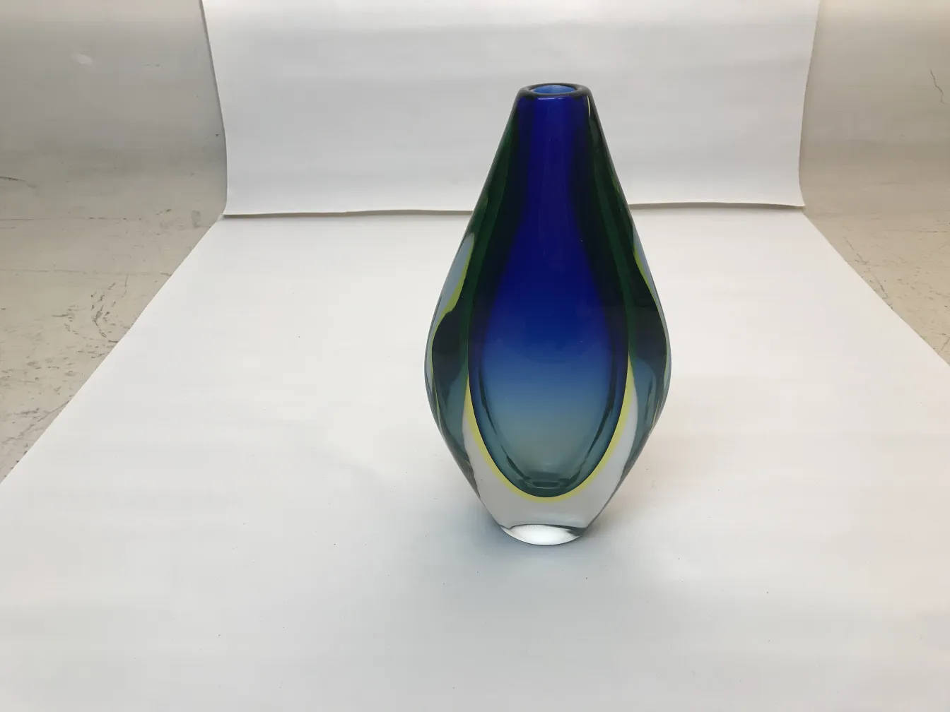 Murano-Glas geschnitzt in eleganten Formen und lebhaften Farben vor einem weißen Hintergrund.
