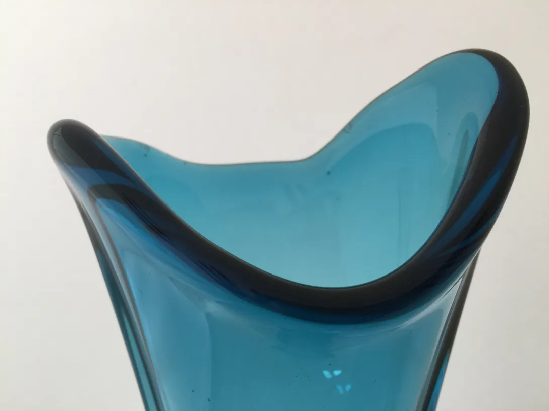 Vaso de Murano azul com borda escura em ambiente claro.