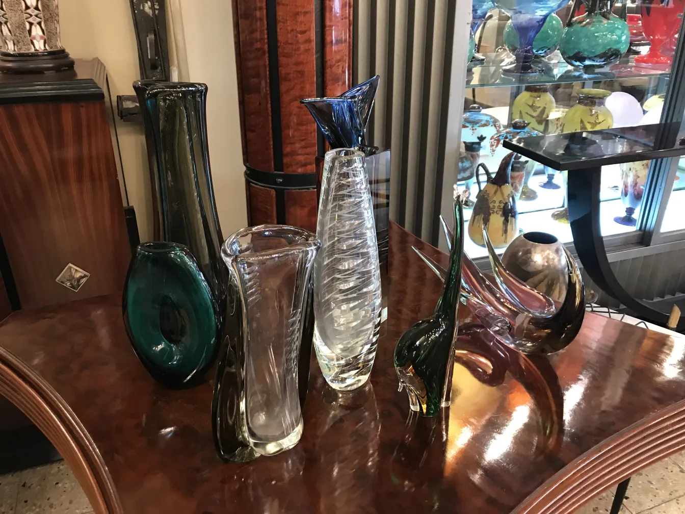 Floreros antiguos de Murano en diversos colores y formas sobre una mesa.