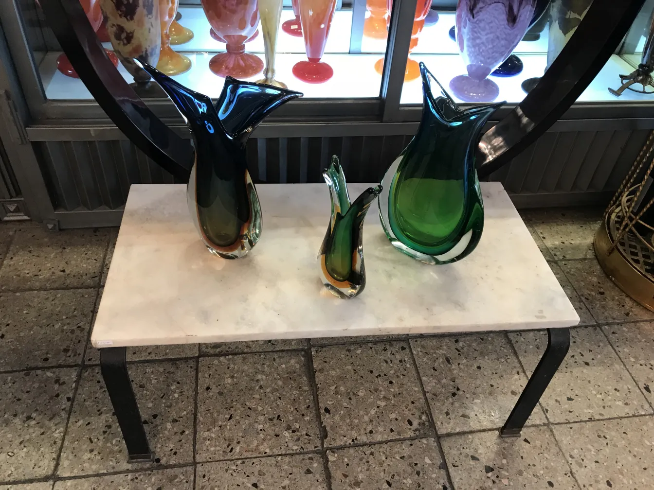 vase antico di murano in tonalità verdi e forme fluide su un tavolo bianco