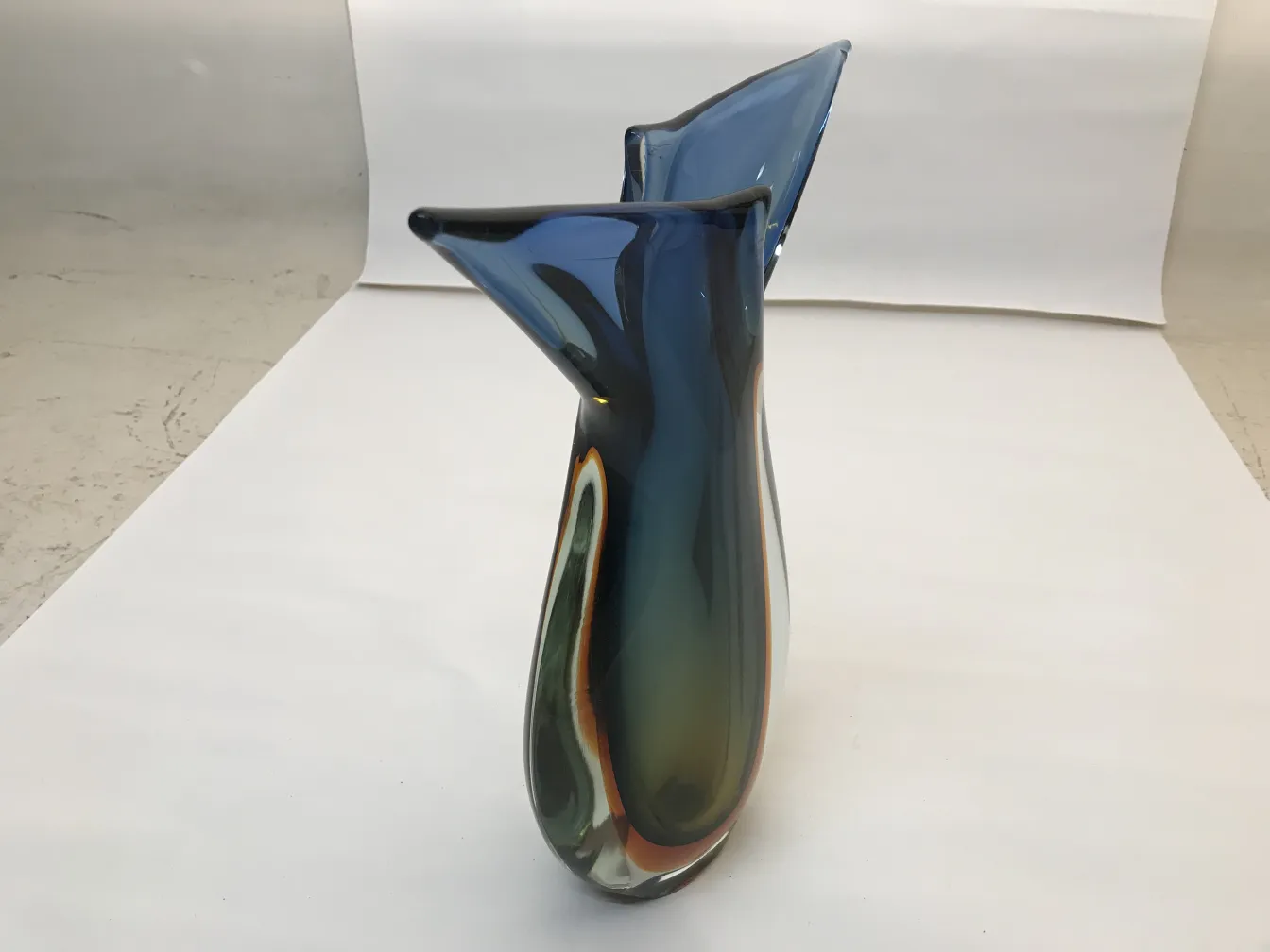 vaso di murano con forma elegante e colori vari su sfondo chiaro