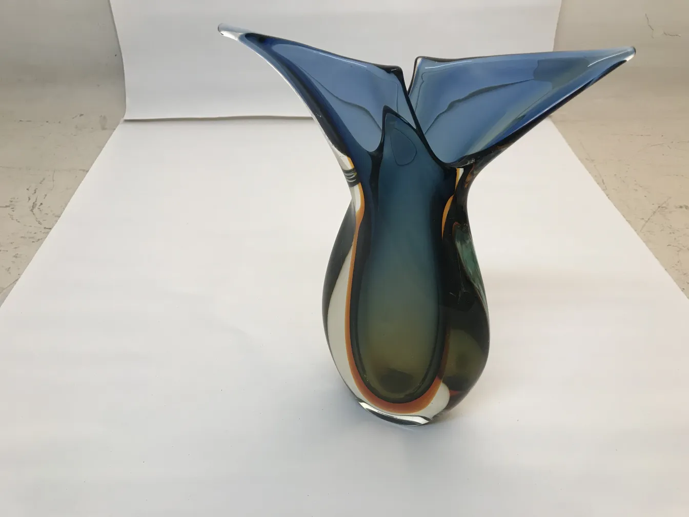 antike murano vase in blauen und grünen farbtönen mit neutralem hintergrund.