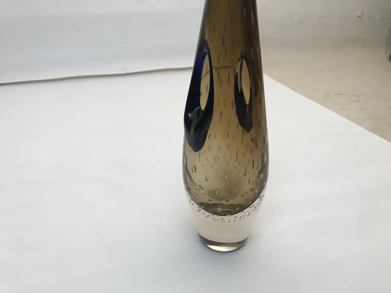 vase murano avec forme élégante et détails en tons fumés et bleus, placé sur fond blanc