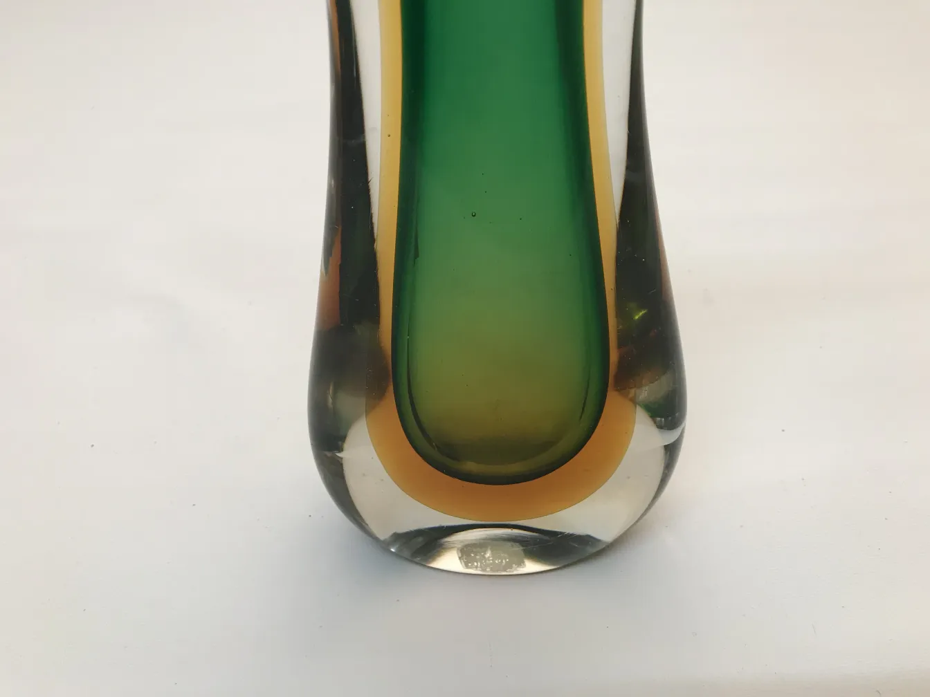 Vaso di Murano colorato con tonalità di verde e giallo, antiguità, in un ambiente semplice.