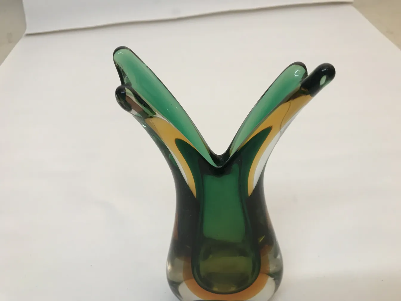 vase murano avec forme stylisée et couleurs vives, sur fond neutre.
