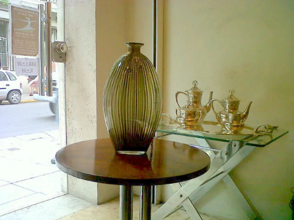 Vaso antigo de Murano em uma mesa com objetos prateados