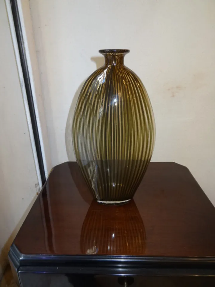 antique murano vase with ribbed design in dark shades, on wooden table