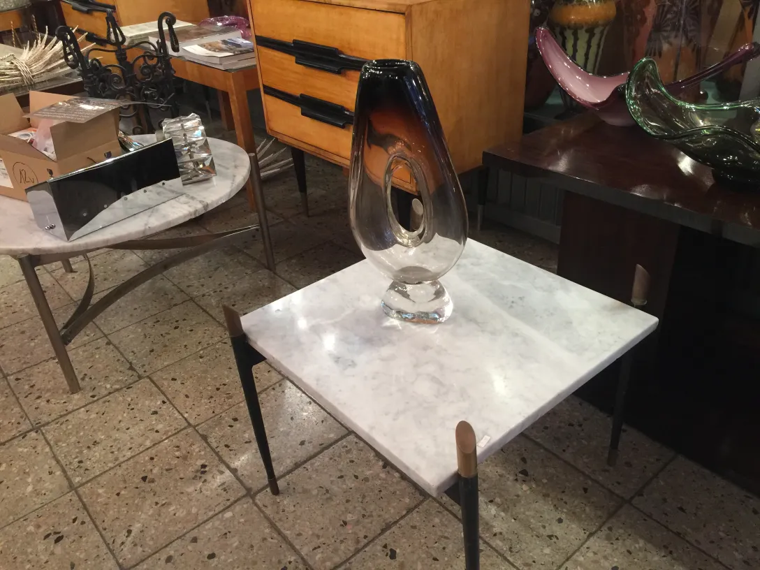 florero de murano en una mesa de mármol con otros objetos