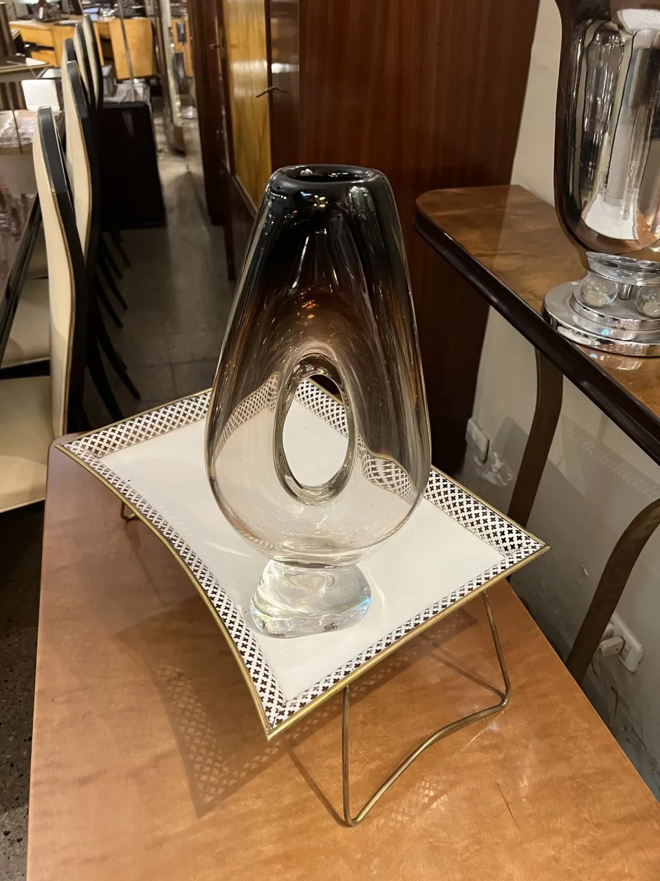 Florero de Murano antiguo con forma distintiva y detalles elegantes en un entorno de antigüedades.