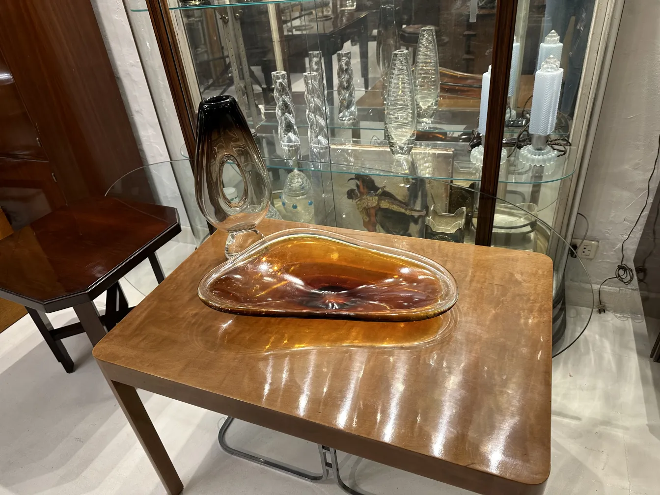 Vase Murano ancien avec forme unique en tons ambre et noir, sur une table en bois.