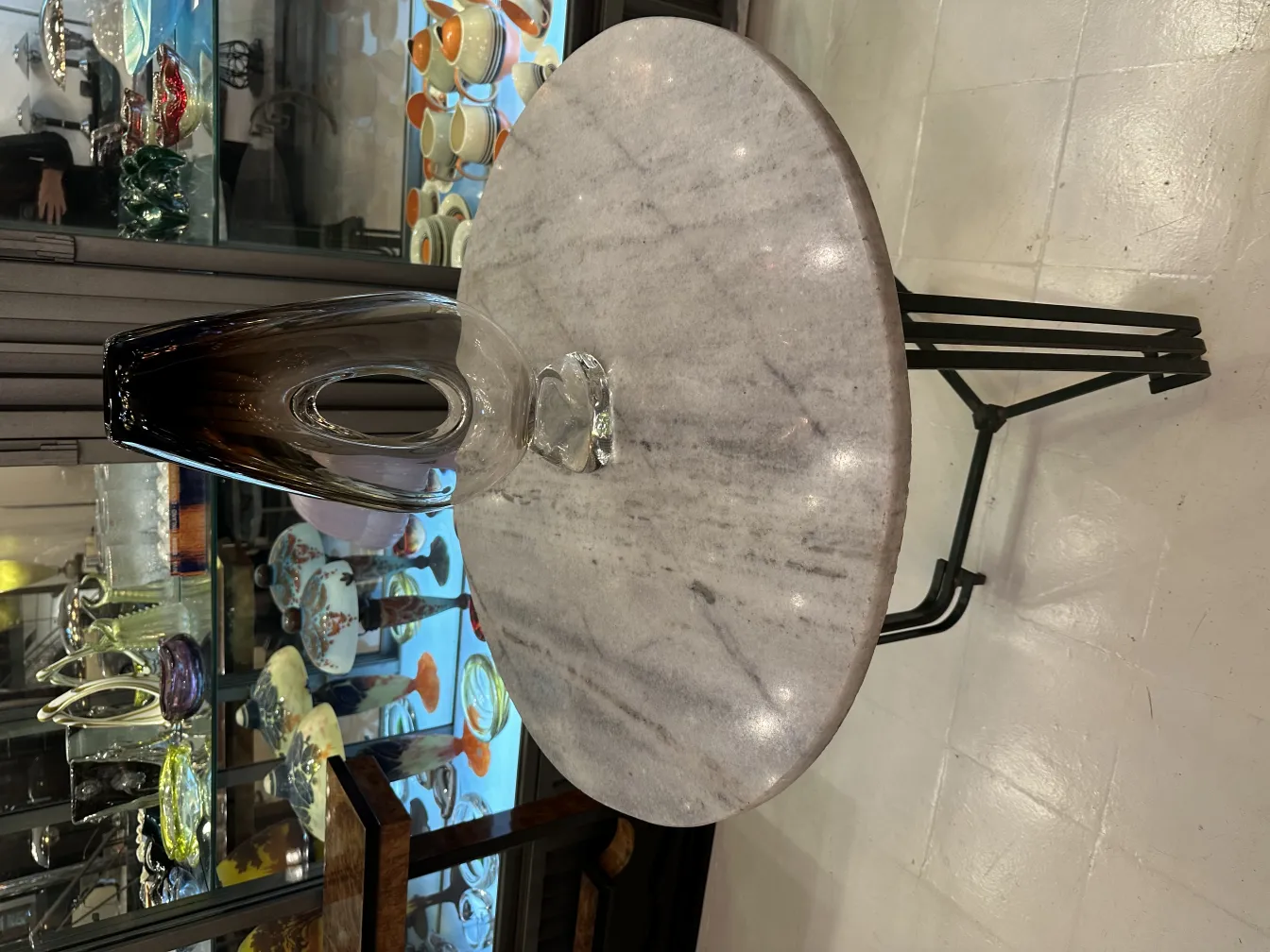 Vase en Murano ancien avec une forme élégante et une teinte sombre, exposé dans un cadre d'antiquités.