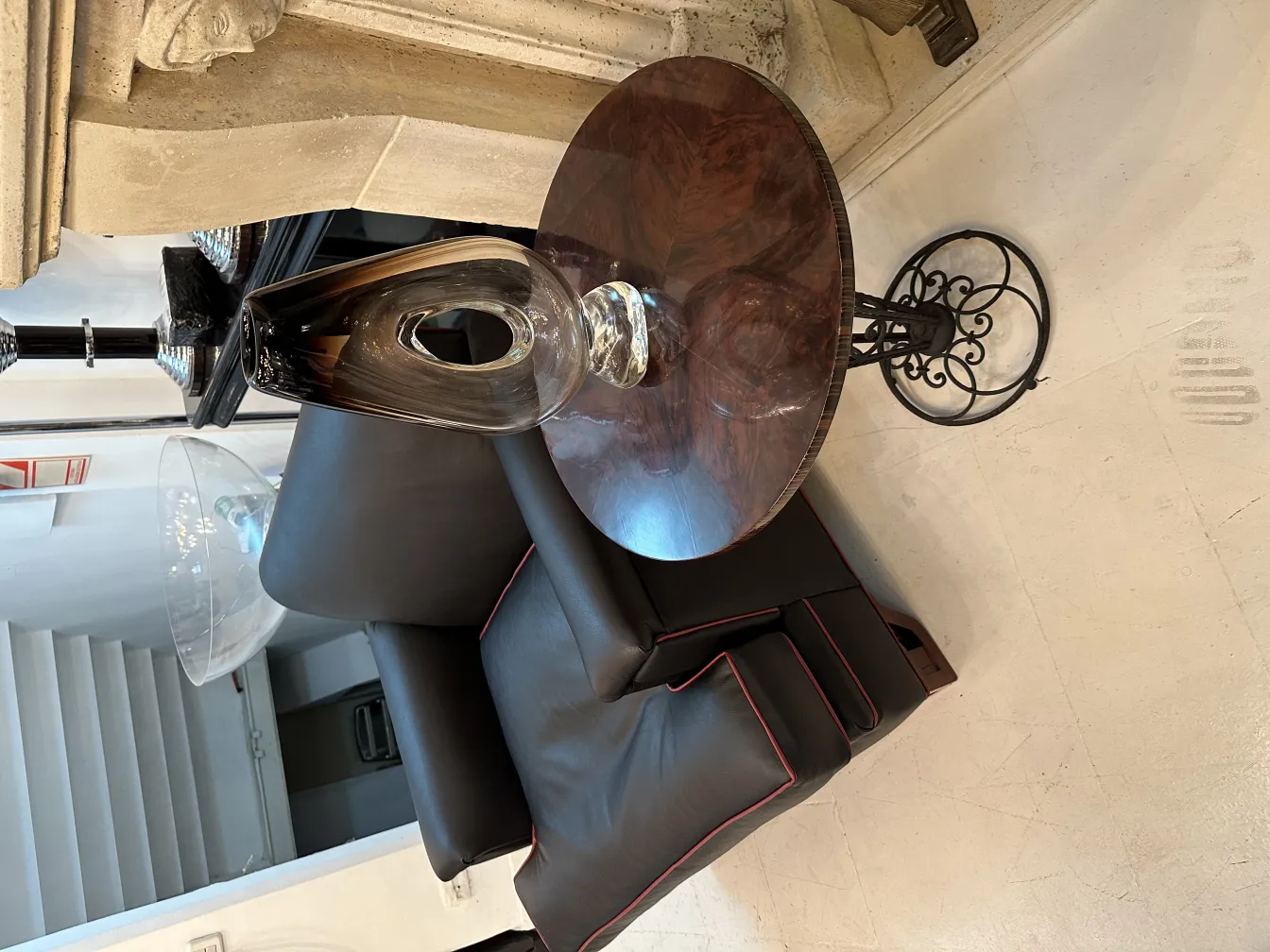 부드럽고 빛나는 표면의 타원형 무라노 꽃병, 어두운 가구가 있는 우아한 배경에 놓여 있음