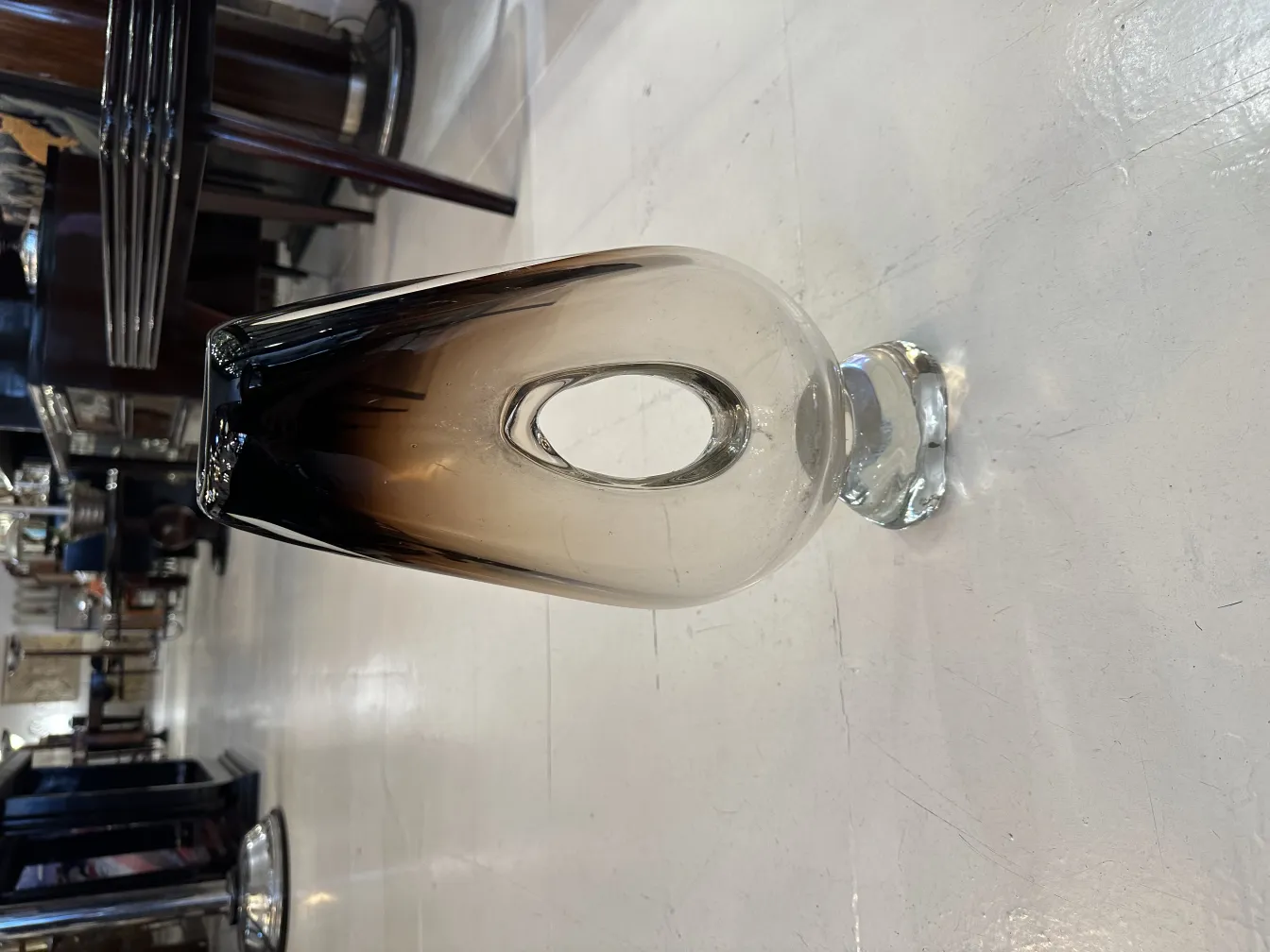 florero de murano con base transparente, ambiente antiguo con muebles elegantemente dispuestos