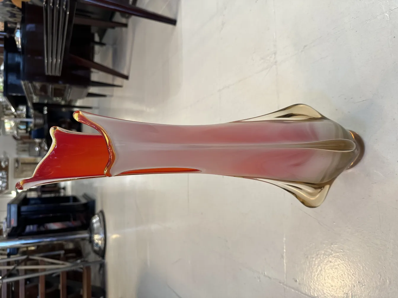 florero de Murano antiguo en tonos cálidos, con forma estilizada, decorando un ambiente elegante