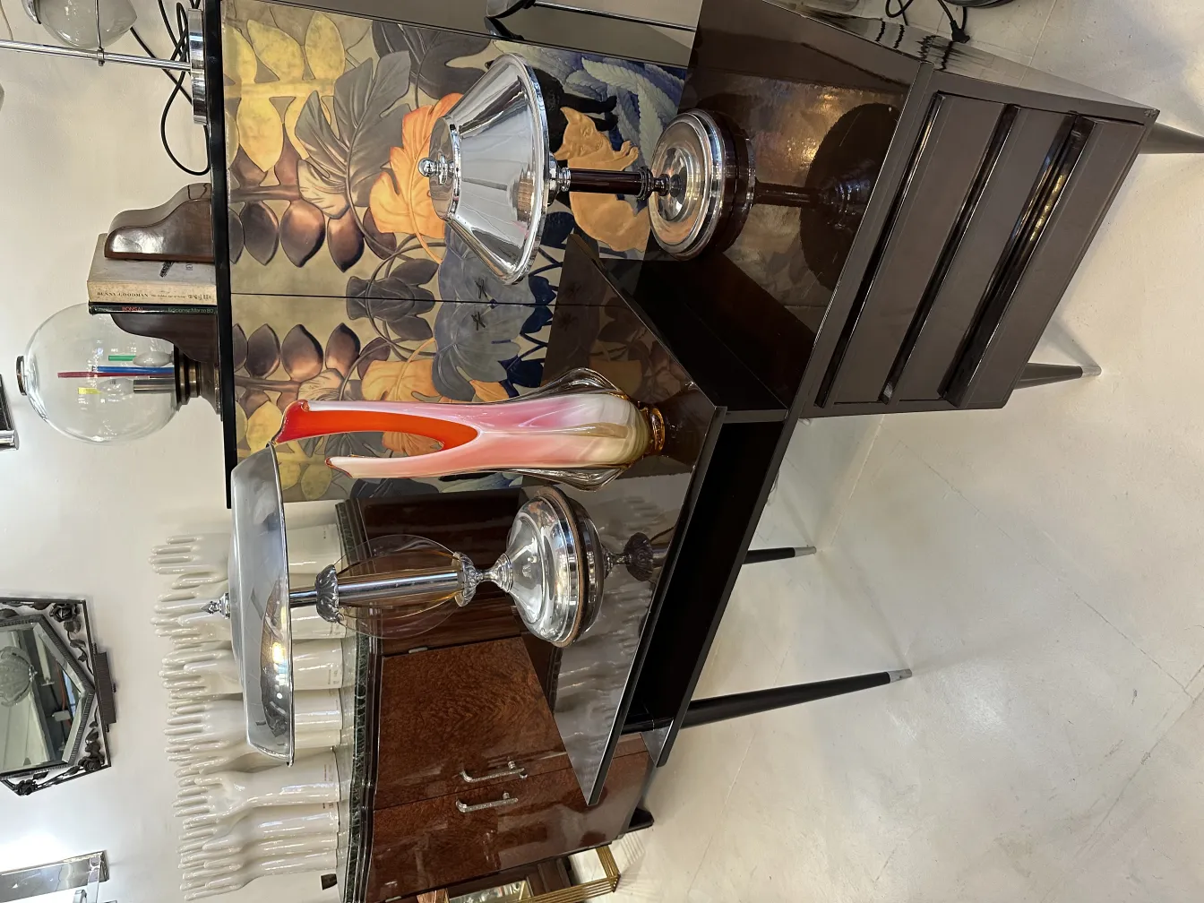 Un elegante vaso di Murano antico su un tavolo stiloso con oggetti decorativi.